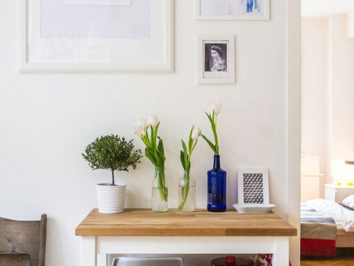 Glass jars of dried leaves and petals on a kitchen shelf
