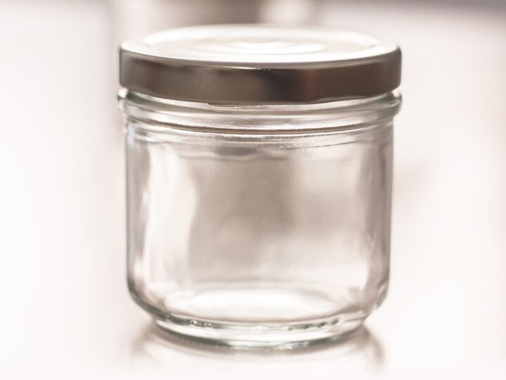 A glass jar of Moroccan preserved lemons packed in coarse salt and cloudy brine